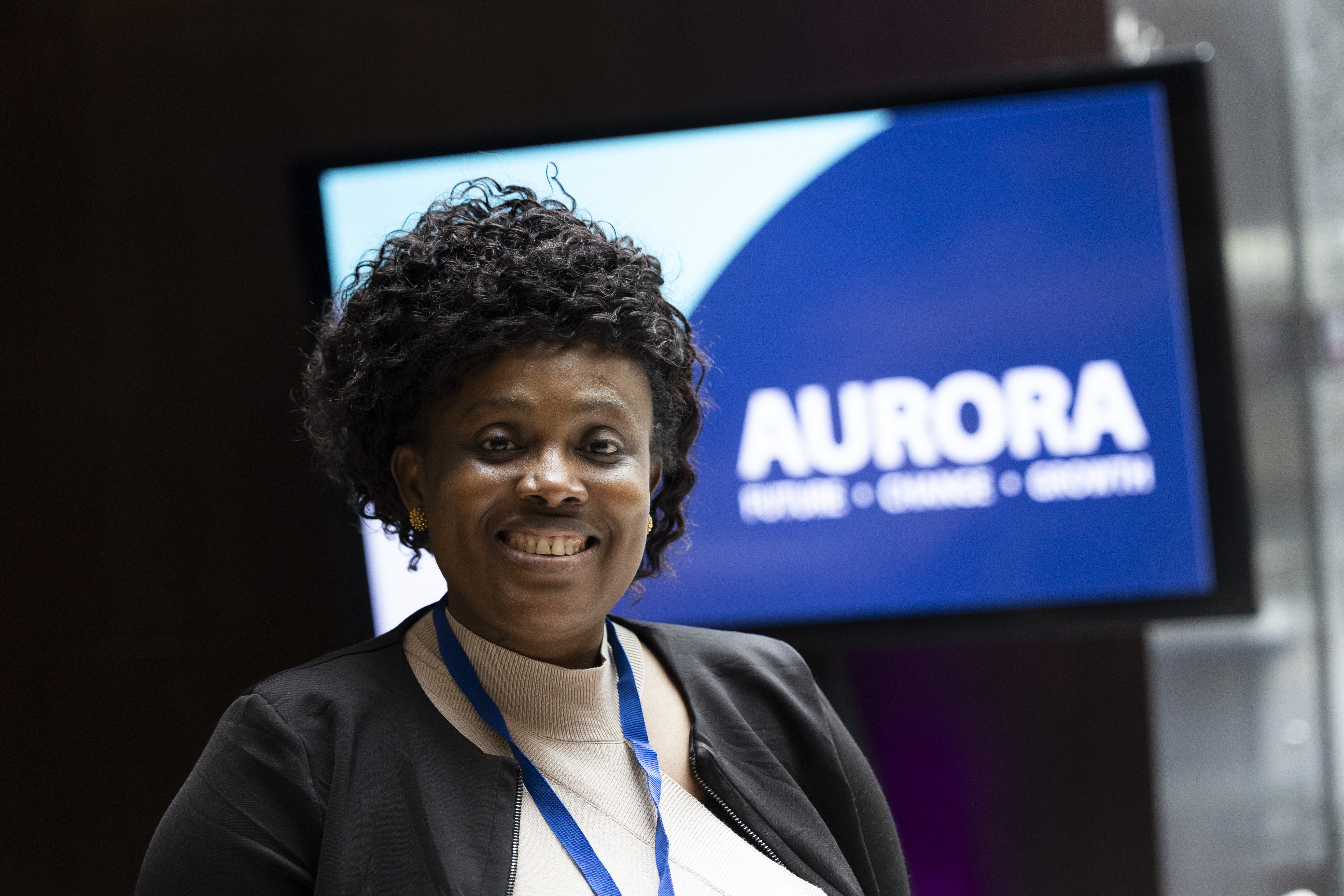 Woman smiling with Aurora programme signage in the background