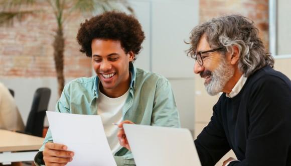 Student and academic sitting side by side to discuss assessment