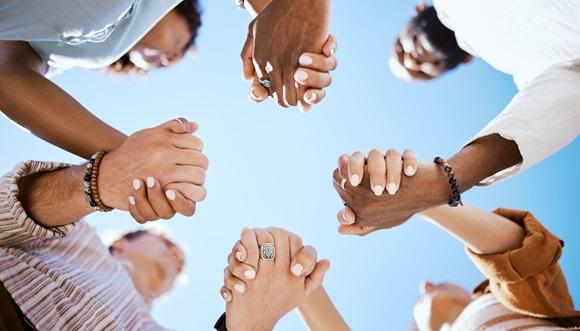A circle of people holding hands in support