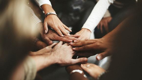 Several hands joined together to signify inclusion and working together