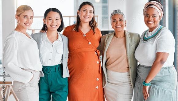 A group of five women of different ethnicity standing with their arms around each other smiling at the camera