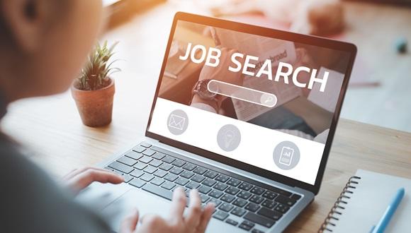A laptop is open with a webpage showing a job search