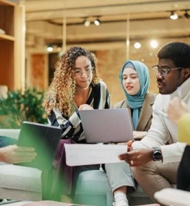 A Group of Multiethnic People Brainstorming Using Laptop and Charts in a Meeting Room 